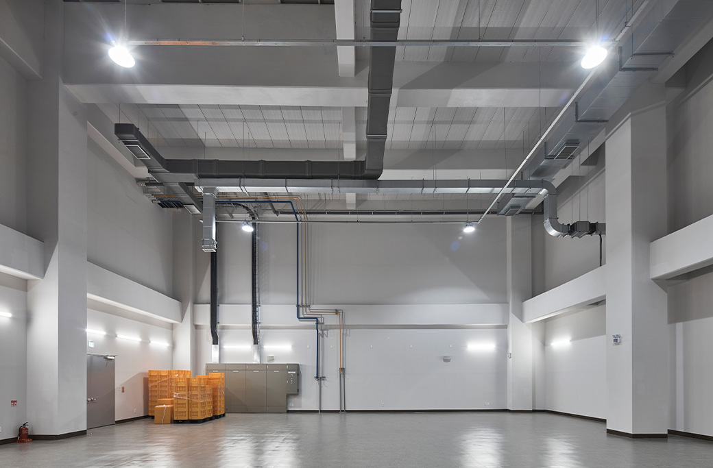 Large industrial mechanical room with exposed ductwork and polished concrete floor.